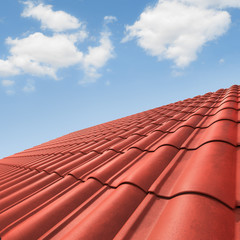 View of red roof tiles and cloudy sky on the background.