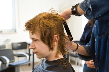 Jugendlicher mit roten langen Haaren beim Frisör
