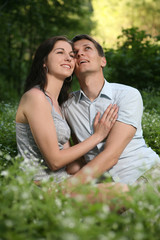 Man and woman sitting on the grass.