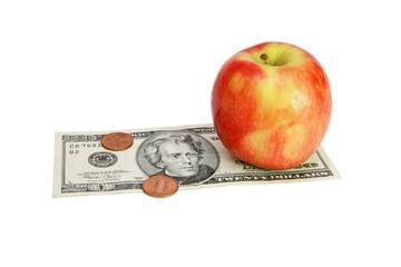 Fresh red apple on twenty dollar bill with coins isolated