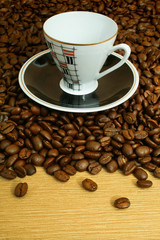 cup with saucer on coffee beans background