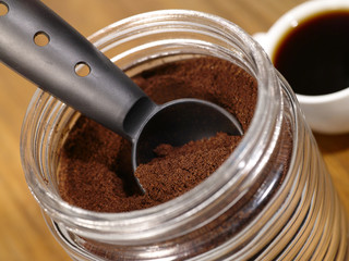 coffee cup on wooden desk with glass mug and sugar