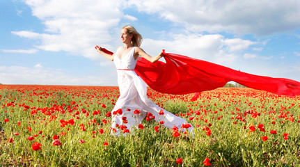 happy woman running with red scarf in poppy field