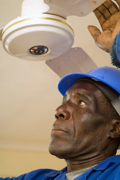 Construction Worker Fixing Ceiling Fan