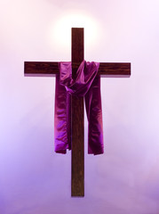 Easter cross with purple sash floating with a glow behind