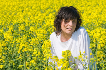 Fototapeta premium Relaxing girl in the rapeseed yellow field