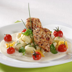 Seasoned meat and gnocchi served with cheese sauce and tomatoes