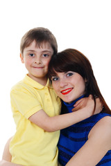 A little boy hugs a young beautiful girl on a white background