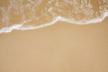 Fototapeta na wymiar Fala na jasnym piasku plaży
