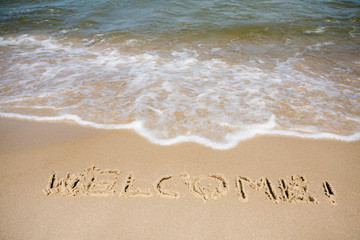 Welcome written in sandy beach