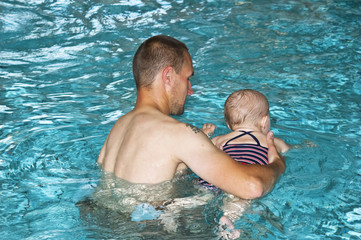 Father with daughter in swimming pool