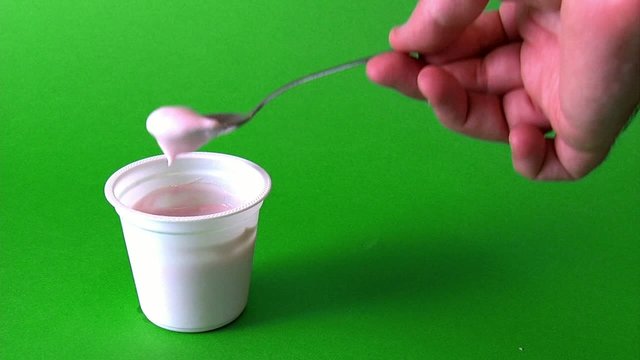 Mano prende yougurt con cucchiaino