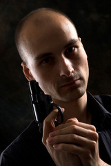 Male Holding a Gun. A low-key portrait