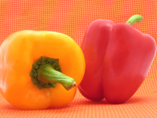 Roter und gelber Paprika vor kariertem Hintergrund