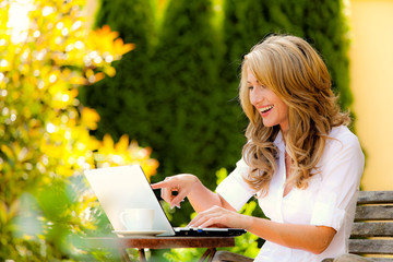 Woman with laptop in garden