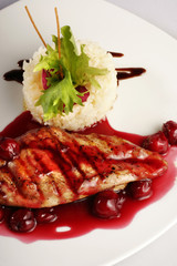 Chicken grill with rice and cherry sauce. Closeup