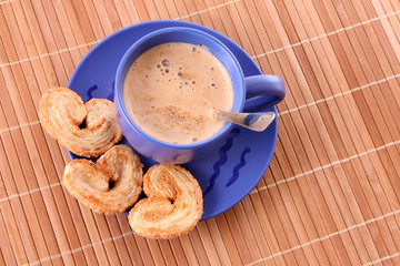 Cup of coffee with milk and cookies isolated over brown backgrou