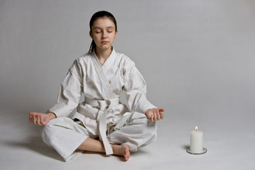 The girl in a sports kimono meditates