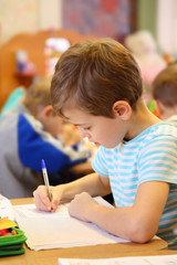 Drawing boy in kindergarten