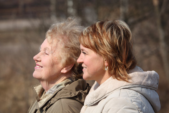 Smiling elderly woman and her daughter in profile