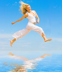 Girl in white jumping happily