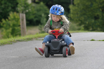 Kind auf Bobbycar, heranfahrend