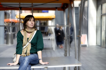 young attractive woman sitting on empty counter