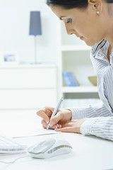 Woman writing at desk