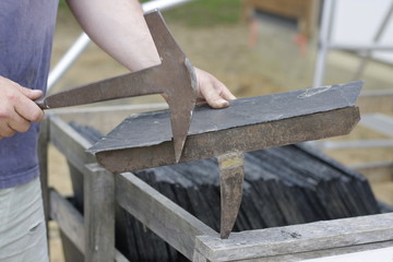 roofer cut a slate on a stack