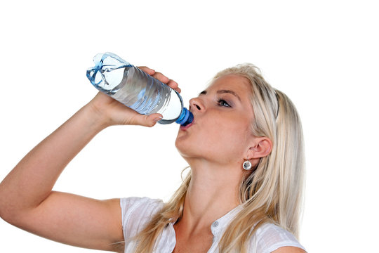 Frau hat Durst und trinkt Mineralswasser aus Petflasche