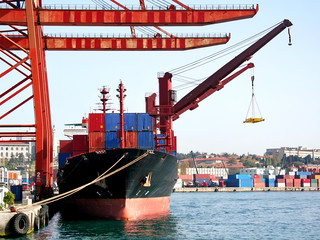 A cargo ship under container cranes