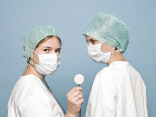 Two female nurses with sugical masks and a stethoscope
