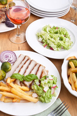 sliced pork chops with fries and brussels sprouts and wine