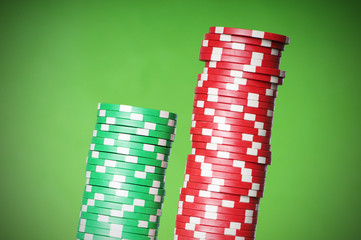 Stack of red and green casino chips against green background