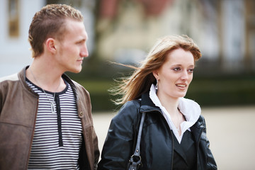 Fototapeta premium Junges Paar geht Arm in Arm spazieren