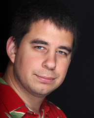 Male portrait on black background with red shirt
