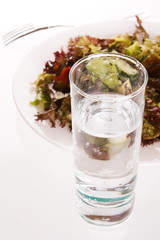 Fresh green salad with glass of water