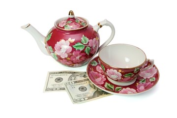 Tea service stands on dollar banknotes isolated