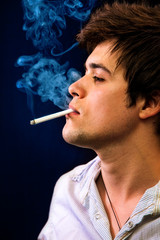 Fototapeta premium Sexy cool young man smoking a cigar