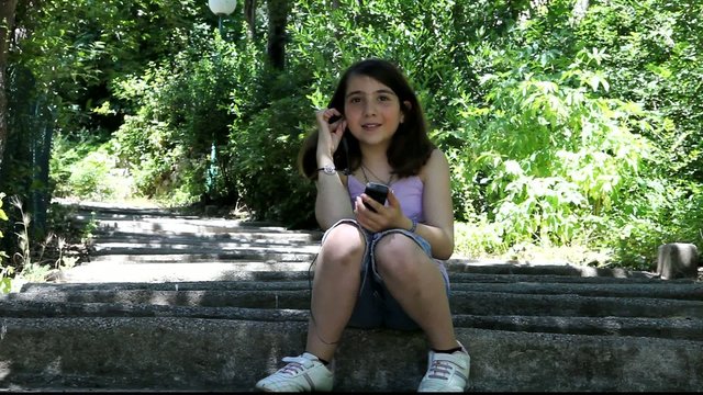 Fillette qui t&eacute;l&eacute;phone sur des escaliers