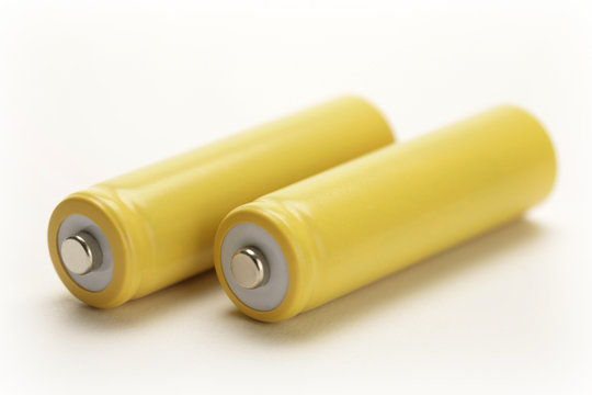 two yellow rechargeable batteries on white background