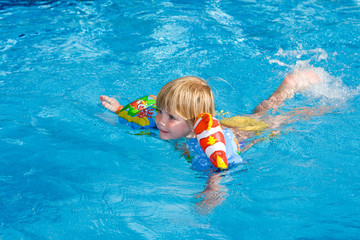 Fototapeta na wymiar Little girl in the swimming pool