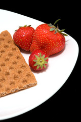 white plate with trawberry and cracker