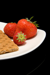 white plate with trawberry and cracker