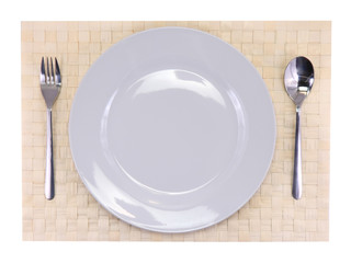 Table appointments(arrangement) of flatware on bamboo mat.