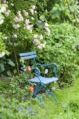Stuhl im Garten unter Rosen