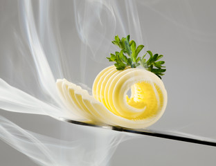 Butter curl on a knife and steam
