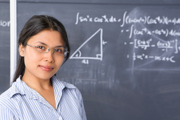 Student pose in front of blackboard