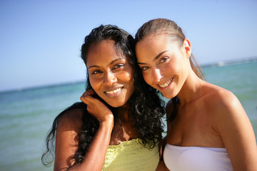 Jolies jeunes femmes souriantes au bord de la plage