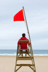 Lifeguard sitting in his chair - obrazy, fototapety, plakaty